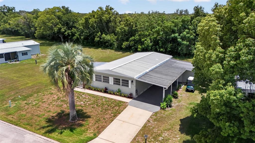 An aerial view shows a single-story house with a metal roof and attached carport — 3712 S CITRUS CIRCLE UNIT GE, ZELLWOOD, FL