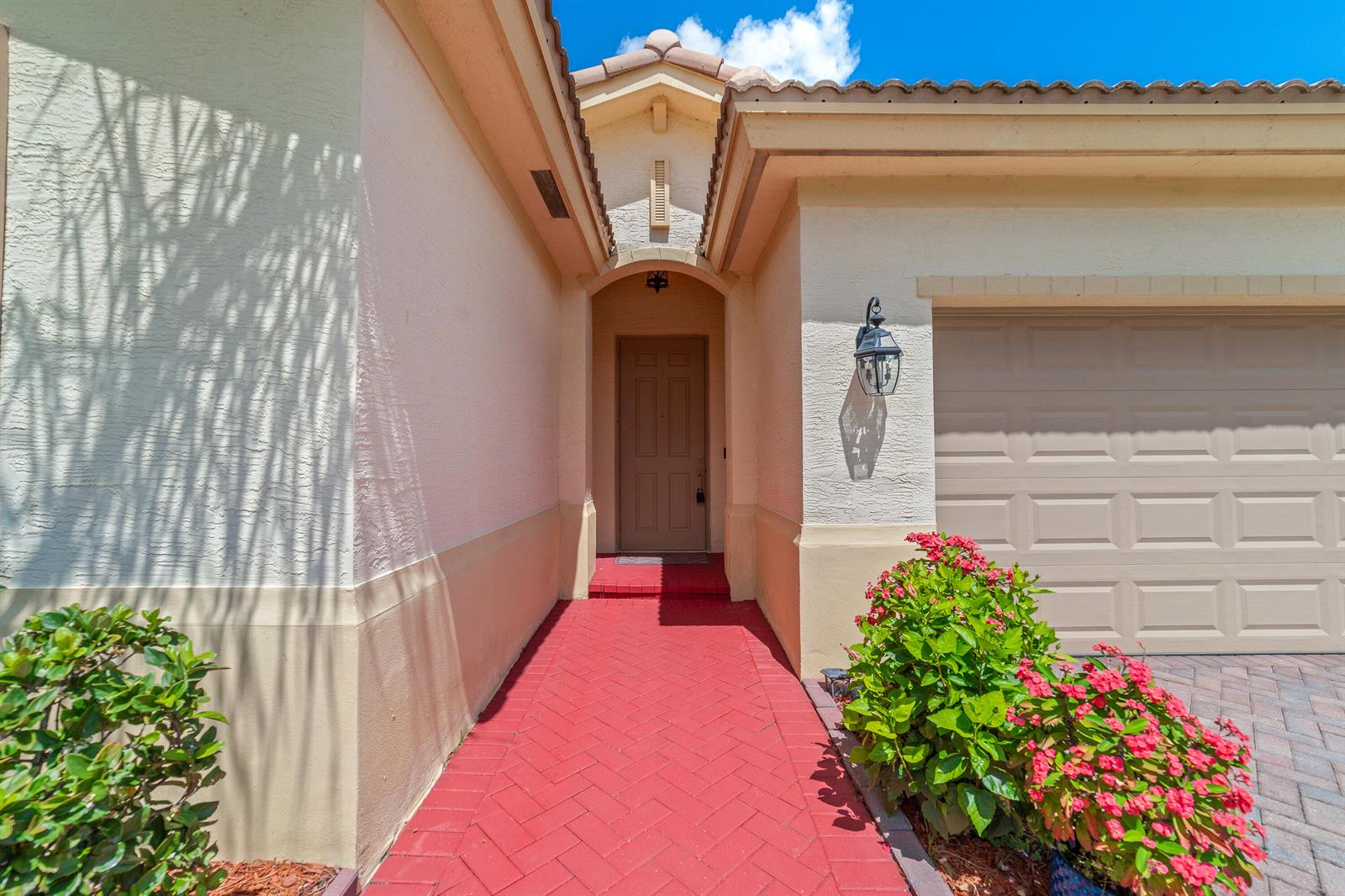 A red brick walkway leads to the front door of a house with a garage — 879 Bent Creek Drive, Fort Pierce FL 34947, FORT PIERCE, FL