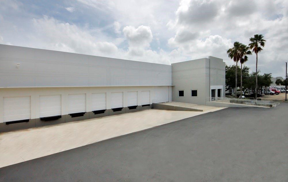 An exterior view of a commercial warehouse building featuring multiple loading docks and a concrete ramp — 3250 N Park Central Boulevard # 100, Pompano Beach FL 33064, POMPANO BEACH, FL