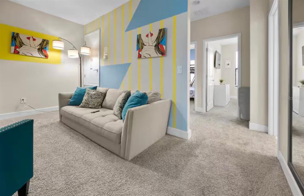 A living room features a beige sofa, patterned wall paint, and a floor lamp — 192 VILLA DOMANI CIRCLE, DAVENPORT, FL