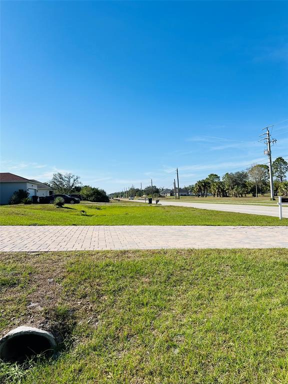A paved driveway leads to a grassy lot with a drainage pipe in the foreground — E PRICE BOULEVARD, NORTH PORT, FL