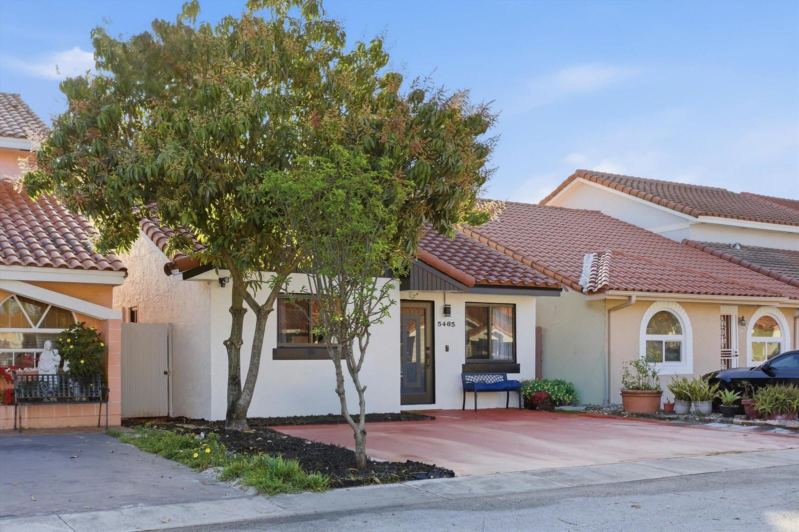 A single-story house with a white stucco facade, red tile roof, and a paved driveway — 5465 W 27th Lane, Hialeah FL 33016, HIALEAH, FL