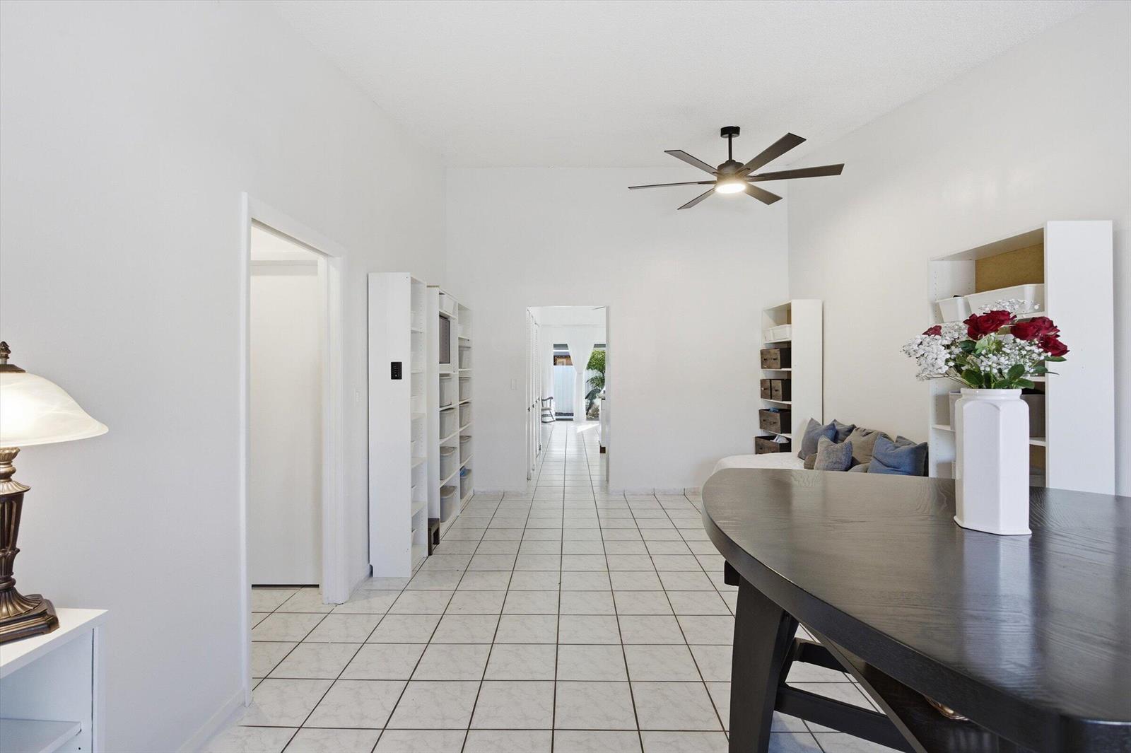 A bright room with white walls, tiled floors, a ceiling fan, and built-in shelving units — 5465 W 27th Lane, Hialeah FL 33016, HIALEAH, FL