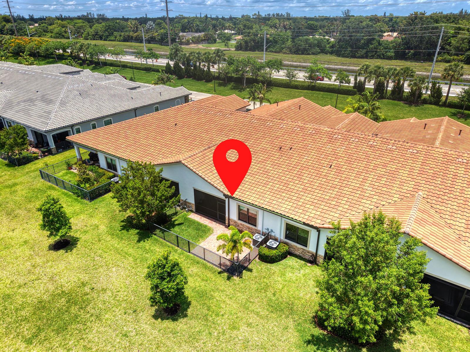 An aerial view shows the rear exterior of a suburban home with a tiled roof — 7524 N Blue Spring Drive, Parkland FL 33067, PARKLAND, FL