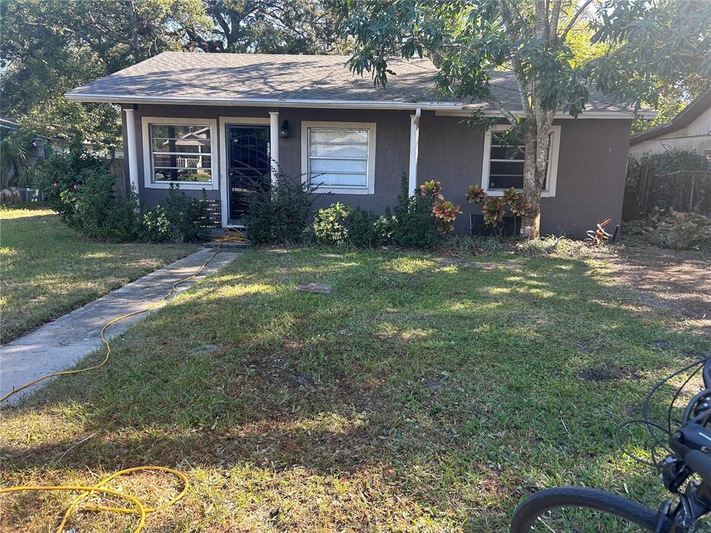 A single-story house with dark gray siding, a shingled roof, and a front yard — 1121 ORANGE AVENUE, SANFORD, FL