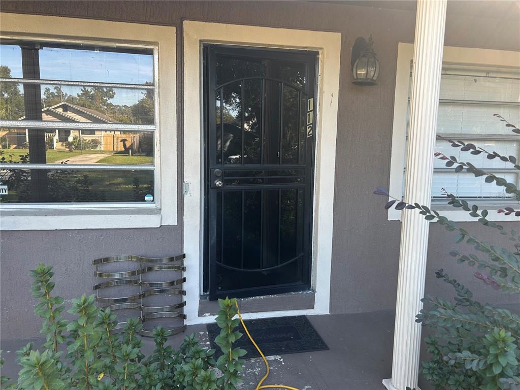 A front entrance features a black security door, a window, and a porch light — 1121 ORANGE AVENUE, SANFORD, FL