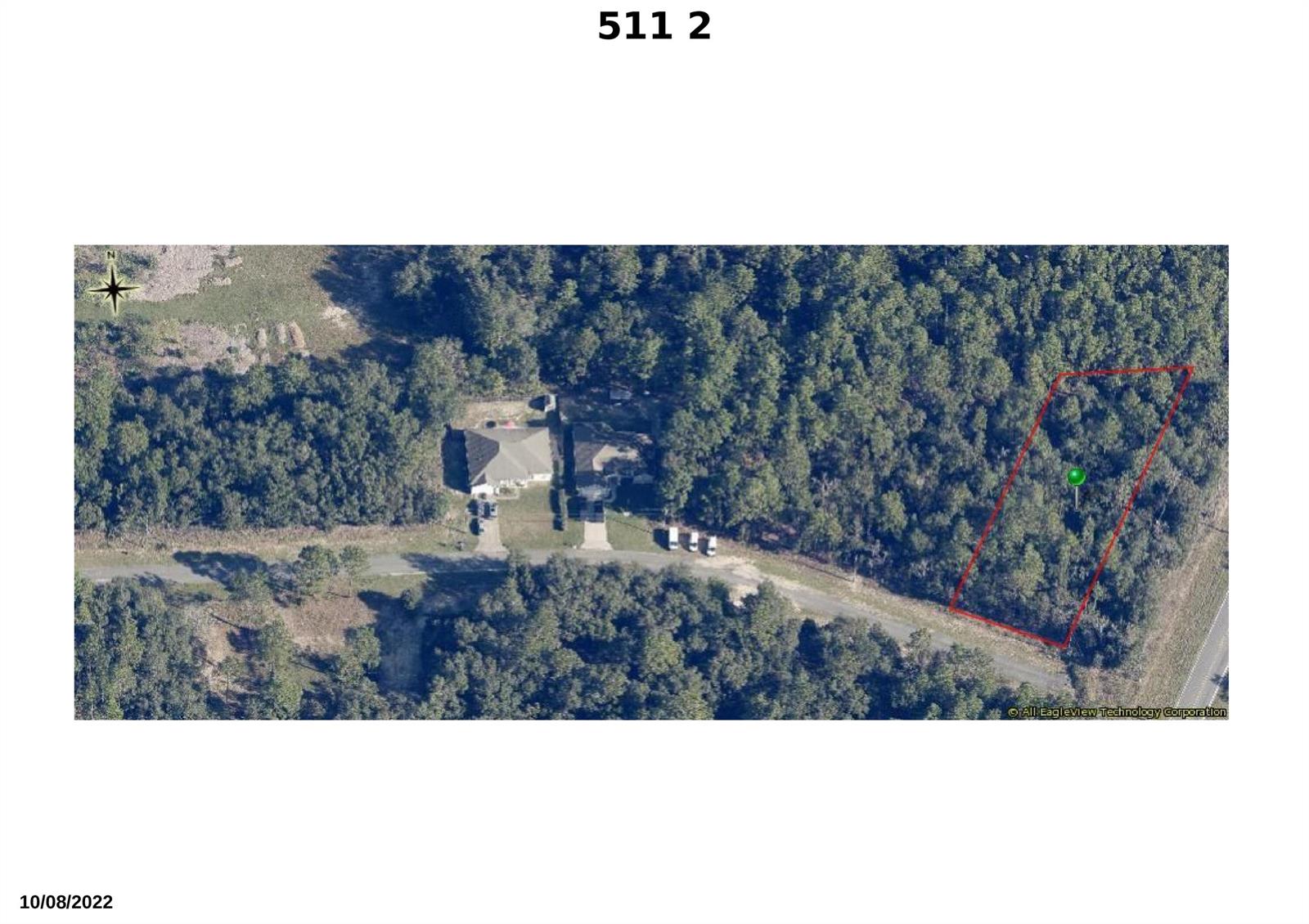 This aerial view shows a residential property with a house and an adjacent wooded lot — 511 W Anderson Lane, FL 34434, FL