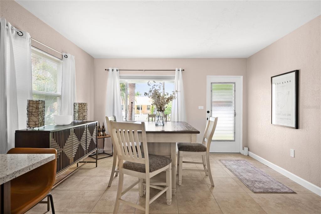 A dining room with a wooden table, four chairs, a sideboard, and a glass door — 2920 57TH STREET S, GULFPORT, FL