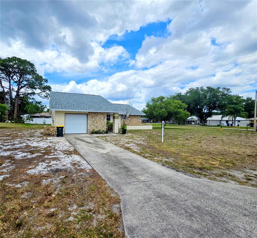 A single-story house with a stone facade and a concrete driveway sits on a lot — 4008 BIANCA STREET, SEBRING, FL