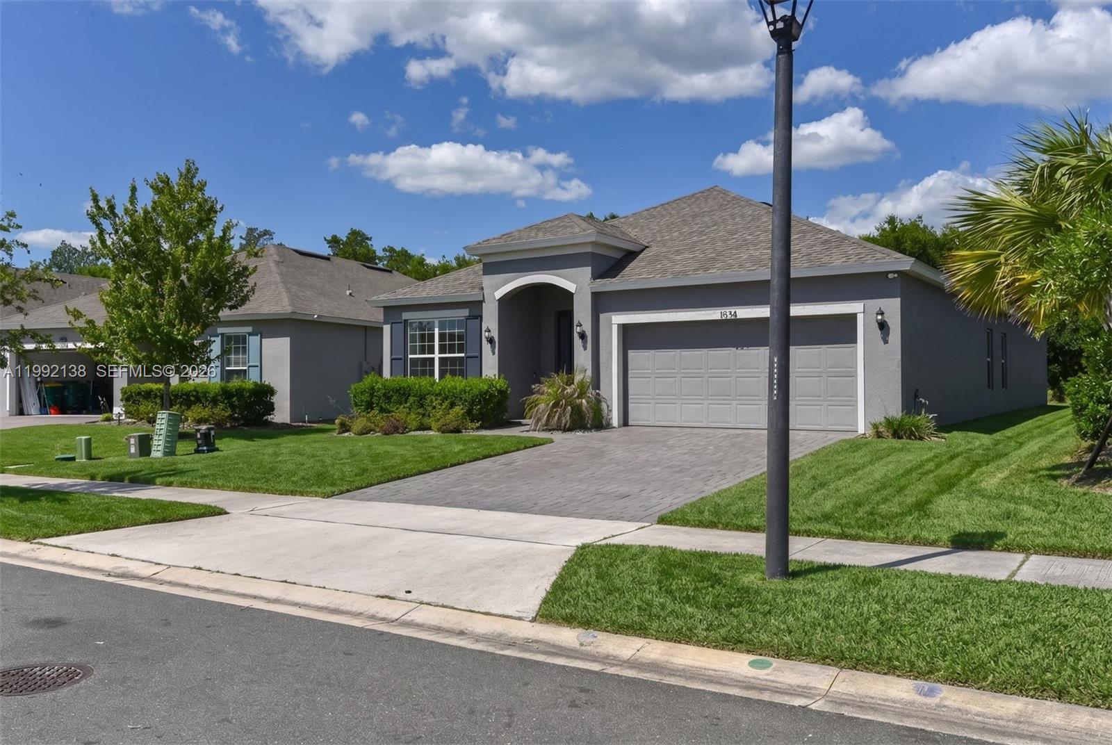 A gray single-story house with a paved driveway and a two-car garage — 1034 CHELAN FALLS DR, Deland FL 32724, DELAND, FL