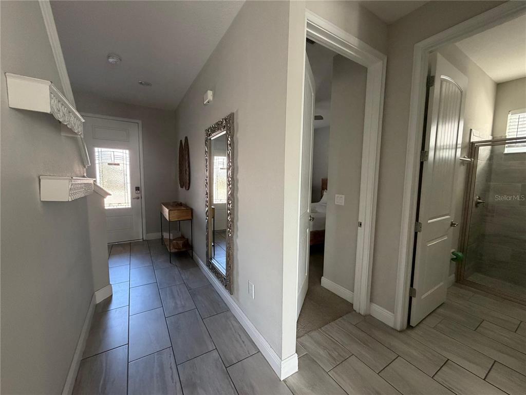A tiled entryway leads to a front door, a mirror, and two interior doorways — 7676 FAIRFAX DRIVE, KISSIMMEE, FL