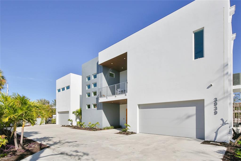 A modern two-story white house with a garage and a second-floor balcony — 3939 HIGEL AVENUE, SARASOTA, FL