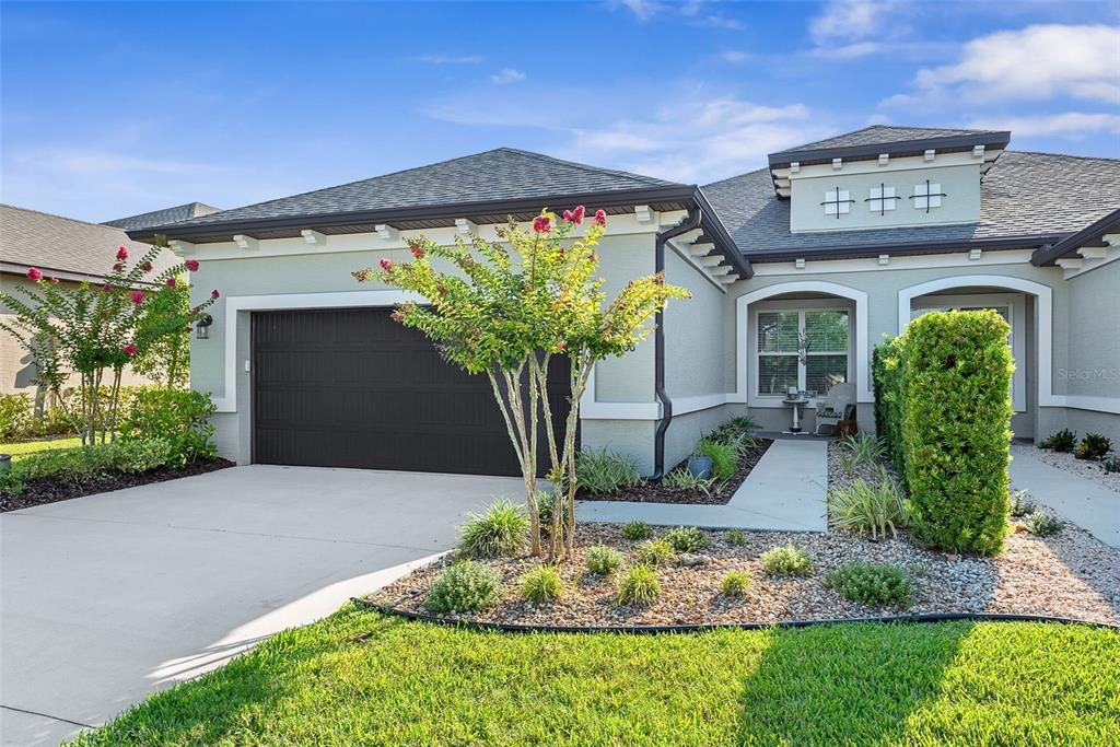 The exterior of a single-story house features a garage, a landscaped yard, and a walkway — 3266 BAILEY ANN DRIVE, ORMOND BEACH, FL