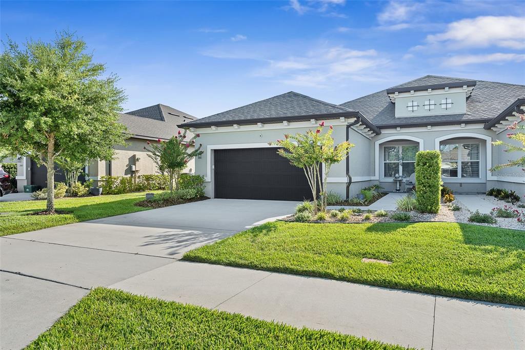 A single-story house with a gray exterior, dark garage door, and a landscaped front yard — 3266 BAILEY ANN DRIVE, ORMOND BEACH, FL