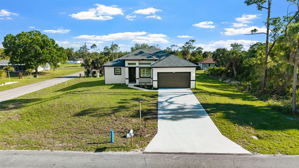 A single-story house with a gray roof, tan exterior, and a concrete driveway — 18265 LAKE WORTH BOULEVARD, PORT CHARLOTTE, FL