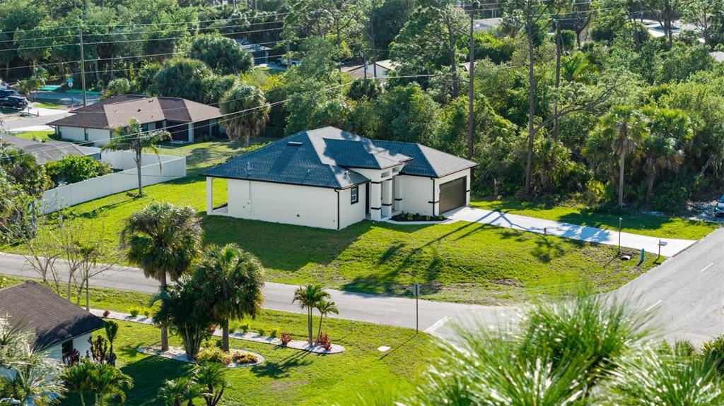 An aerial view shows a single-story house with a dark roof and a concrete driveway — 18265 LAKE WORTH BOULEVARD, PORT CHARLOTTE, FL
