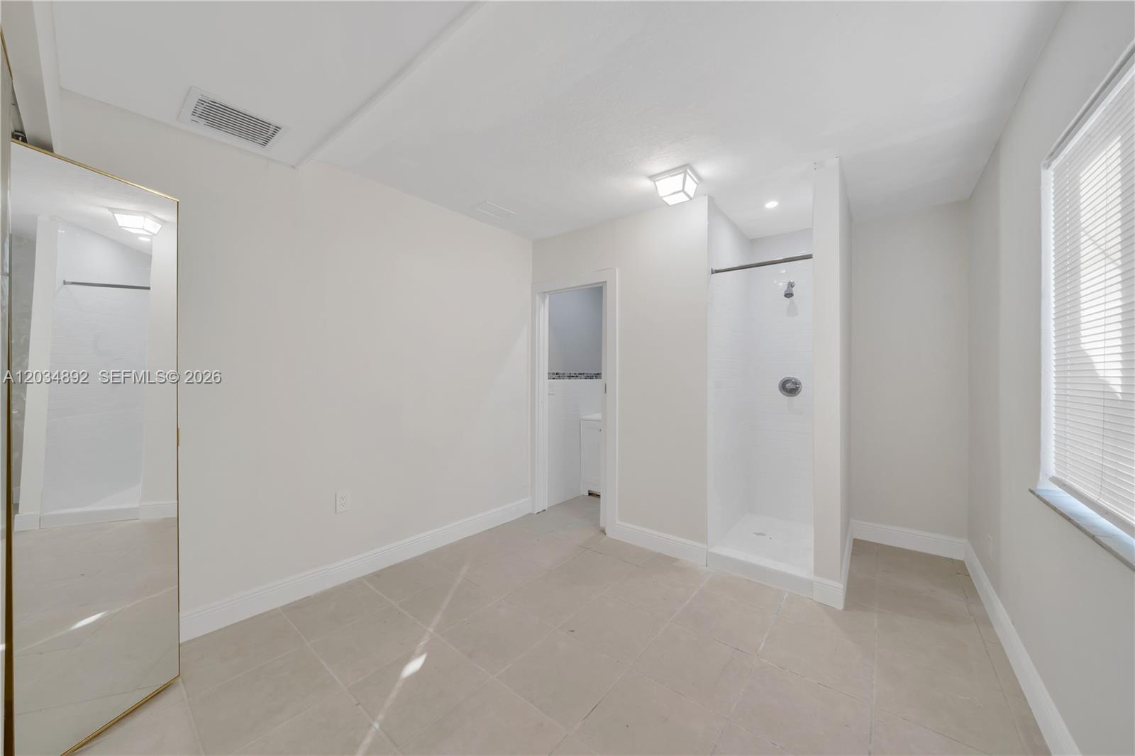 A room with light tile flooring, a walk-in shower, and a doorway to a bathroom — 7555 SW 28th St Rd # b, Miami FL 33155, MIAMI, FL
