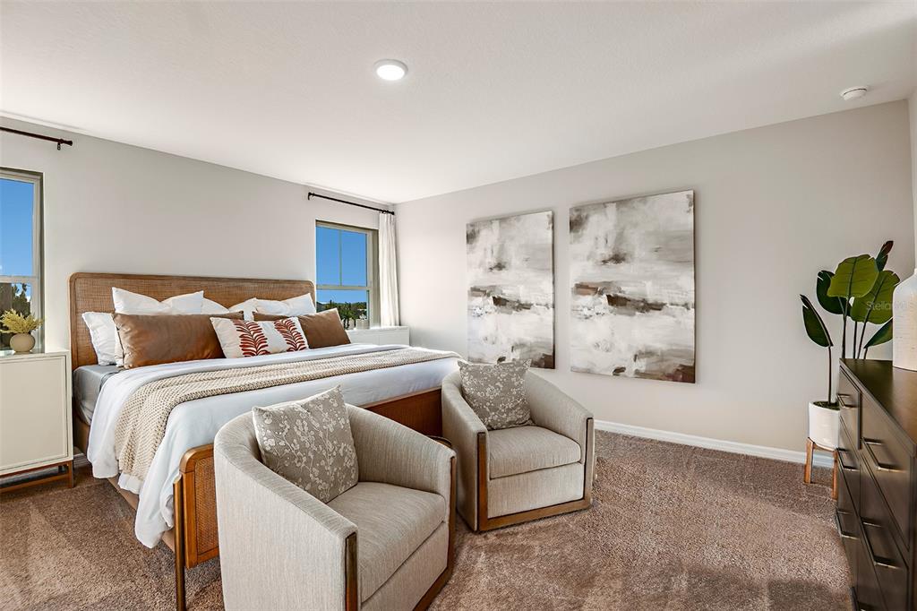 A bedroom features a king bed, two armchairs, abstract wall art, and a potted plant — 4337 RIVERBEND BOULEVARD, HAINES CITY, FL