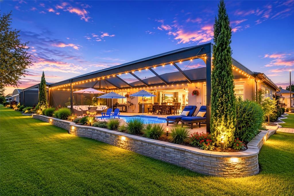A covered patio features a fire pit table, swimming pool, and views of a golf course — 8690 SW 61ST LOOP, OCALA, FL