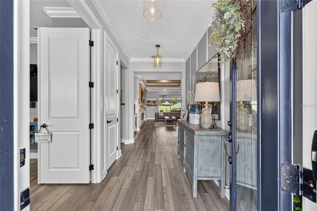 A view from an entryway looking down a hallway toward a living room with wood floors — 8690 SW 61ST LOOP, OCALA, FL