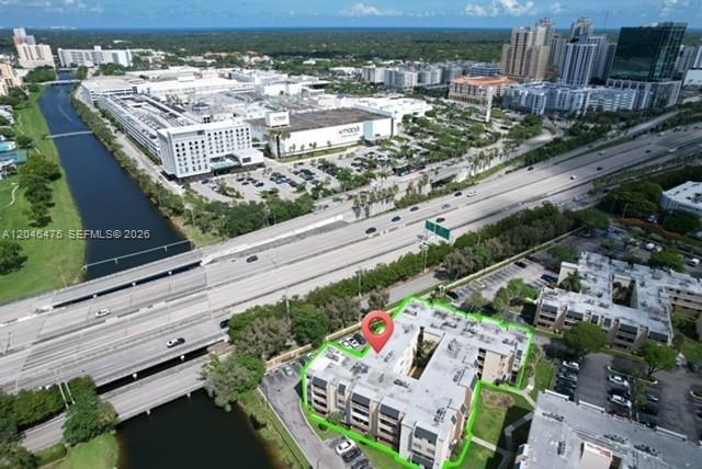 An aerial view shows a multi-story apartment building highlighted in green next to a canal — 7715 SW 86th St # 205, Miami FL 33143, MIAMI, FL