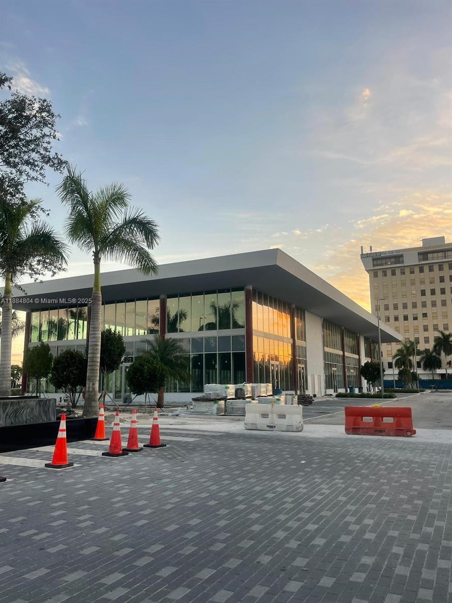 A modern, glass-walled commercial building under construction stands near a paved parking lot — 1006 E HALLANDALE BEACH BLVD # 106, Hallandale Beach FL 33009, HALLANDALE BEACH, FL