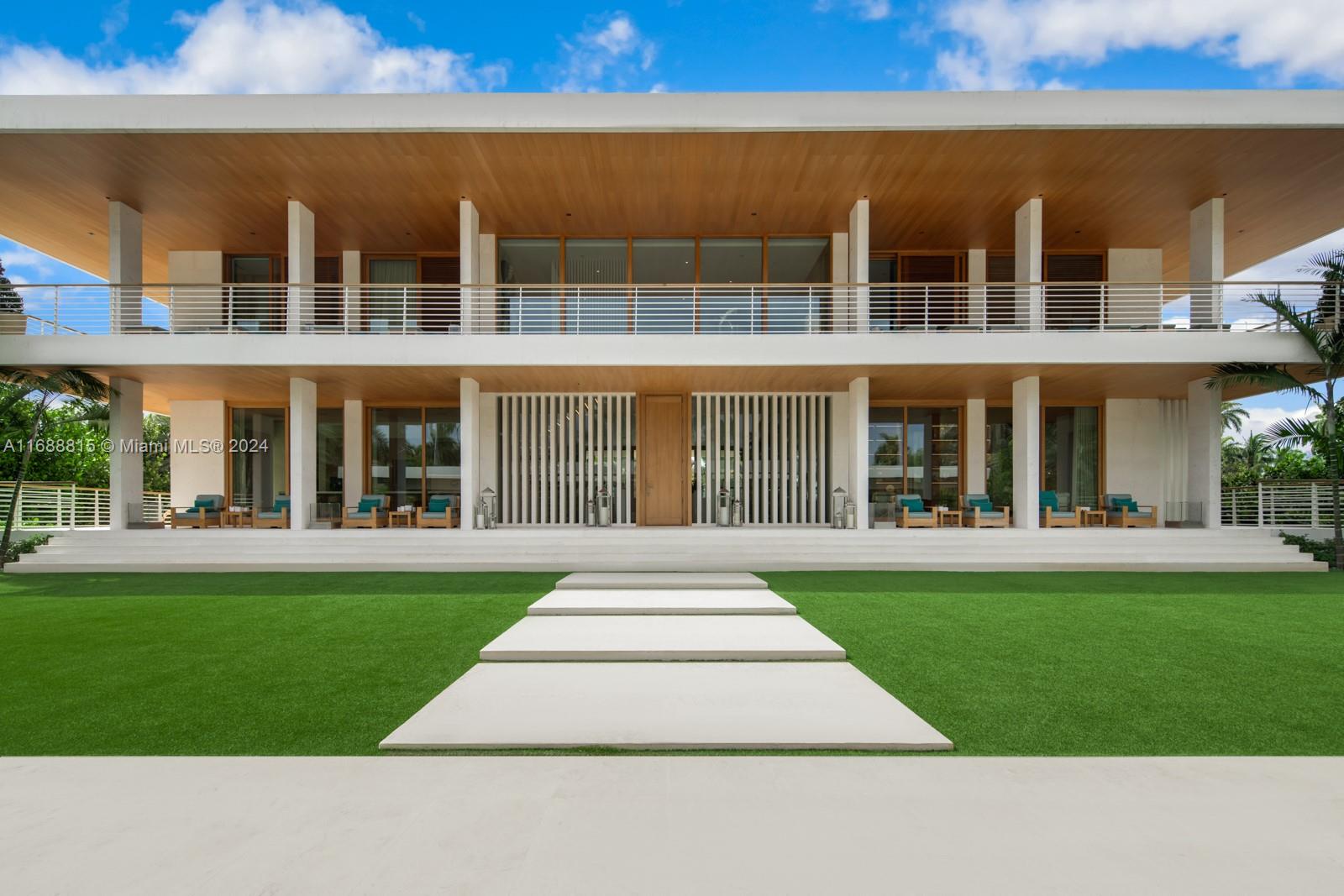 A modern two-story house features a wooden ceiling, white columns, and a stone walkway — 1510 W 25th St, Miami Beach FL 33140, MIAMI BEACH, FL