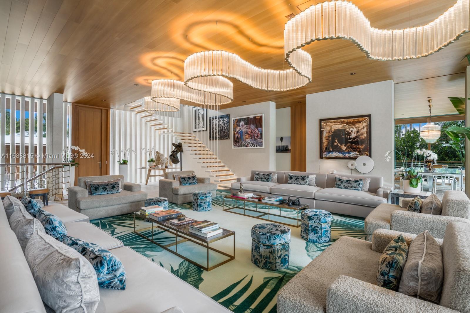 A spacious living room features a large sectional sofa, patterned ottomans, and a unique serpentine chandelier — 1510 W 25th St, Miami Beach FL 33140, MIAMI BEACH, FL