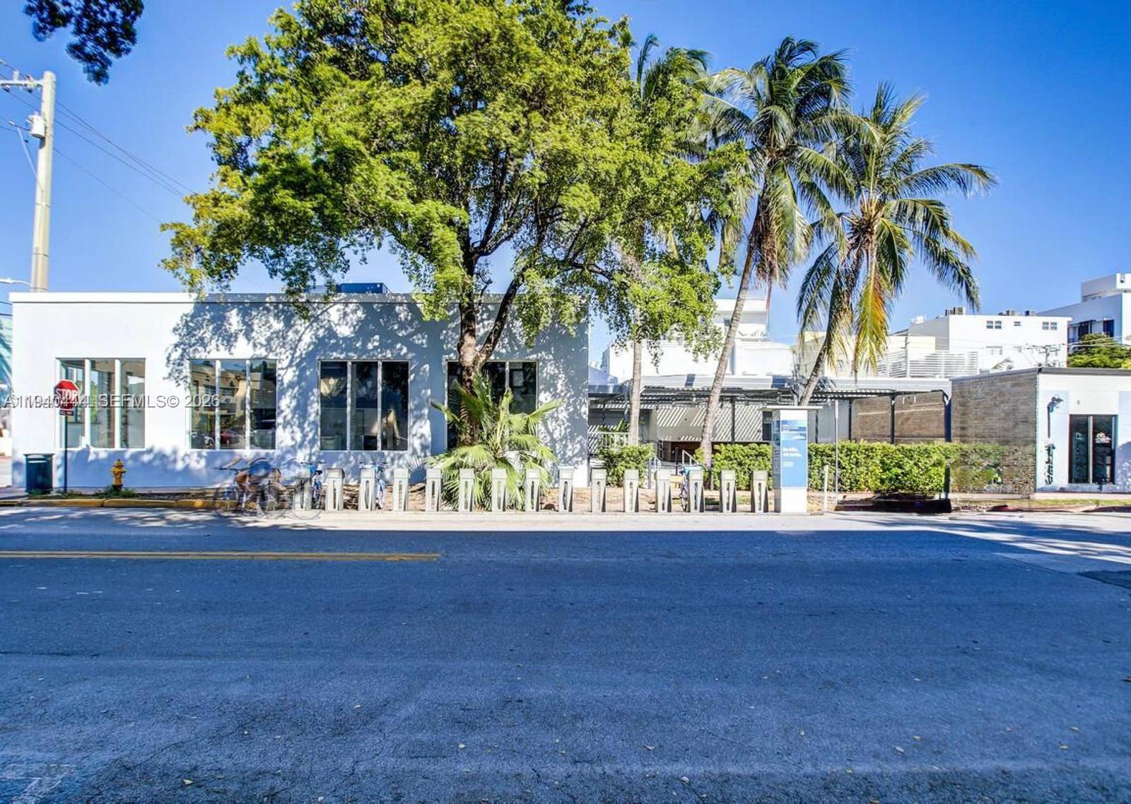 A single-story white building with large windows sits behind a row of bike racks — 555 Jefferson Ave, Miami Beach FL 33139, MIAMI BEACH, FL