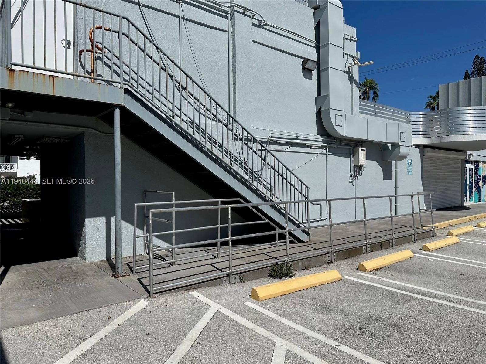 An exterior view of a building featuring a metal staircase and a wheelchair ramp — 555 Jefferson Ave, Miami Beach FL 33139, MIAMI BEACH, FL