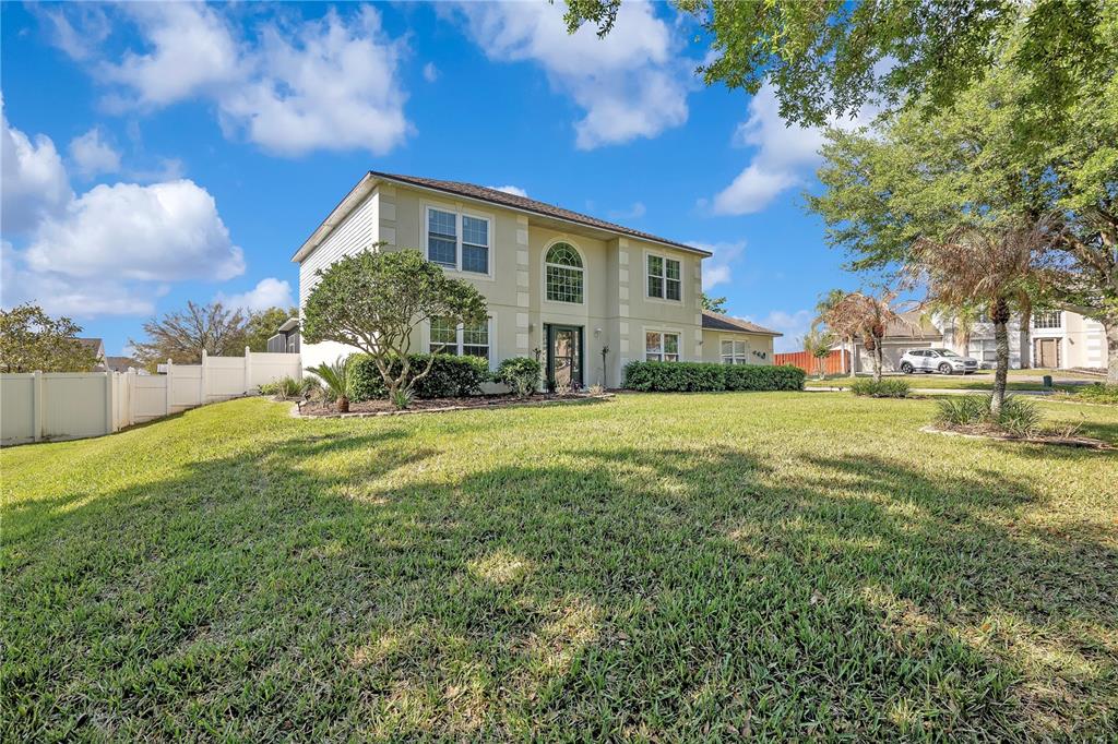 A two-story house with a light-colored exterior, a front yard, and a white fence — 16012 HORIZON COURT, CLERMONT, FL