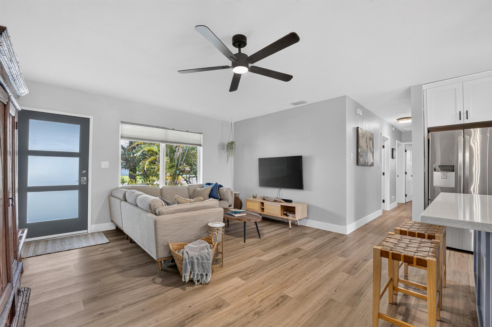 A living room with a sectional sofa, television, ceiling fan, and wood-look flooring — 510 NE 8th Street, Pompano Beach FL 33060, POMPANO BEACH, FL