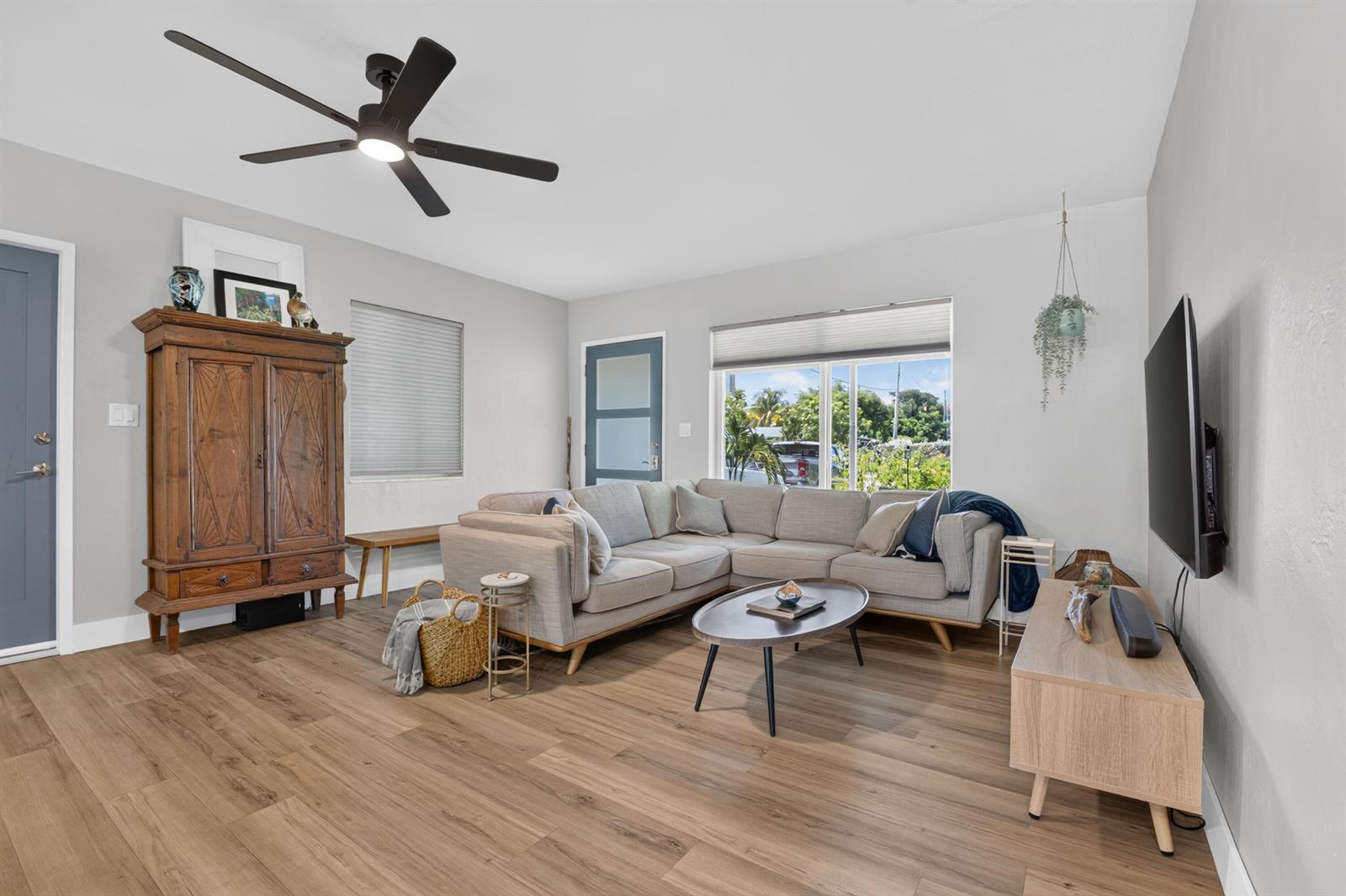 A living room features light wood flooring, a gray sectional sofa, and a wooden armoire — 510 NE 8th Street, Pompano Beach FL 33060, POMPANO BEACH, FL