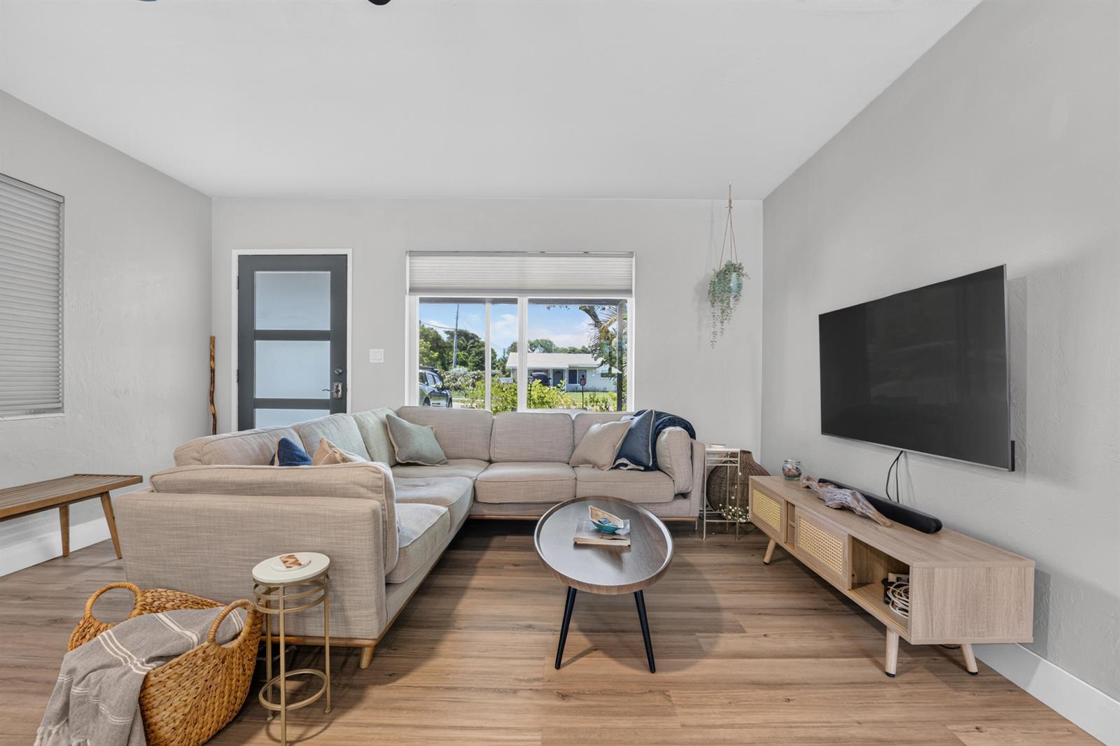 A living room features a light gray sectional sofa, a wooden media console, and wood-look flooring — 510 NE 8th Street, Pompano Beach FL 33060, POMPANO BEACH, FL