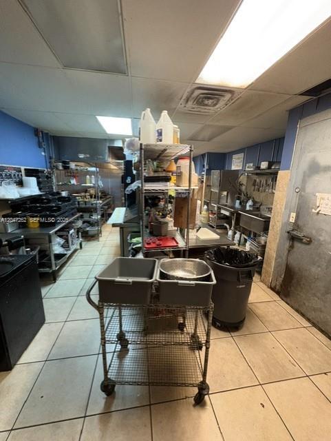 This commercial kitchen features stainless steel equipment, wire shelving, and a rolling utility cart — MIAMI, FL