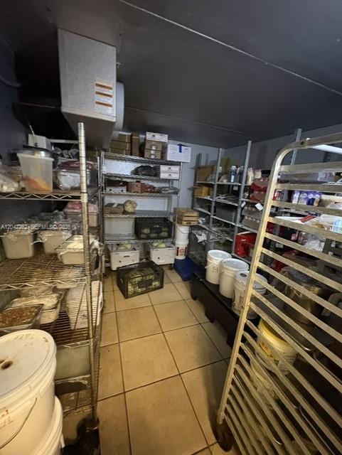 A commercial walk-in cooler features metal shelving units, storage containers, and a cooling unit — MIAMI, FL