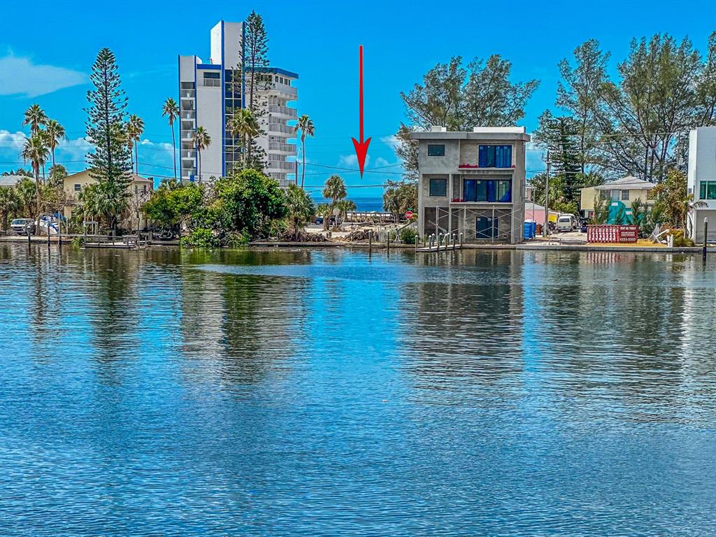 A view of a waterfront lot with a red arrow pointing toward the ocean horizon — 10126 TARPON DRIVE, TREASURE ISLAND, FL