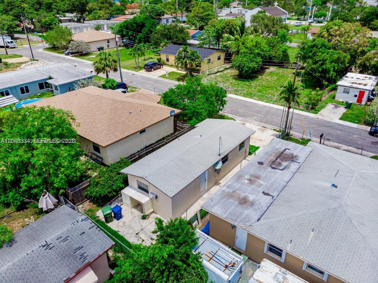 An aerial view shows several residential houses with shingled roofs and surrounding trees and streets — 805 NW 3rd Ter, Hallandale Beach FL 33009, HALLANDALE BEACH, FL