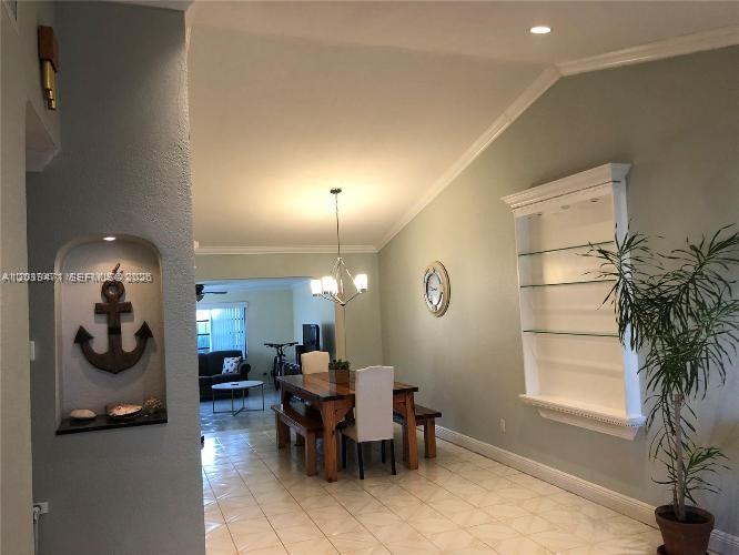 A dining area features a wooden table, chairs, a chandelier, and built-in wall niches — 5813 SW 140th Ave # 5813, Miami FL 33183, MIAMI, FL