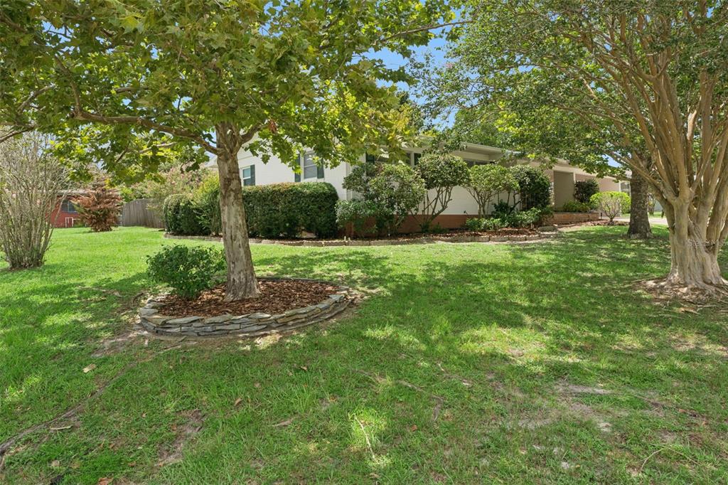 A single-story house with a white exterior, green shutters, and mature trees in the yard — 31 JASMINE DRIVE, DEBARY, FL