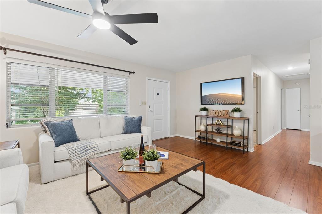 A living room features a white sofa, a wooden coffee table, and a wall-mounted television — 31 JASMINE DRIVE, DEBARY, FL