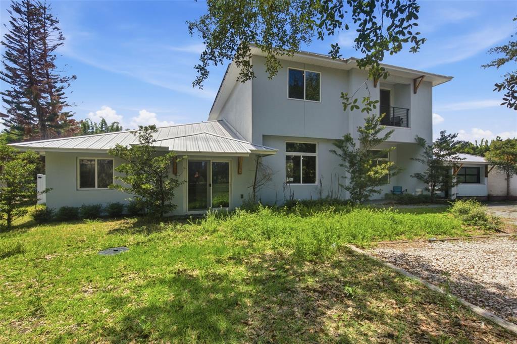 The exterior of a two-story house with a metal roof and a gravel driveway — 281 BREWER AVENUE, WINTER PARK, FL