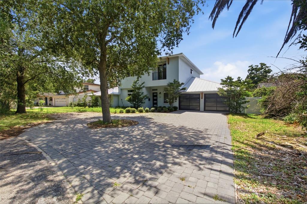 A two-story house with a paved driveway, a large tree, and a two-car garage — 281 BREWER AVENUE, WINTER PARK, FL