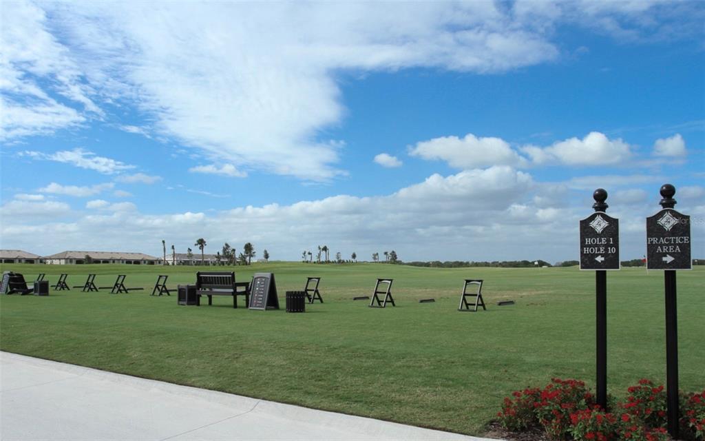 A view of a golf course with directional signs and a bench on the grass — 16814 VARDON TERRACE UNIT 201, BRADENTON, FL