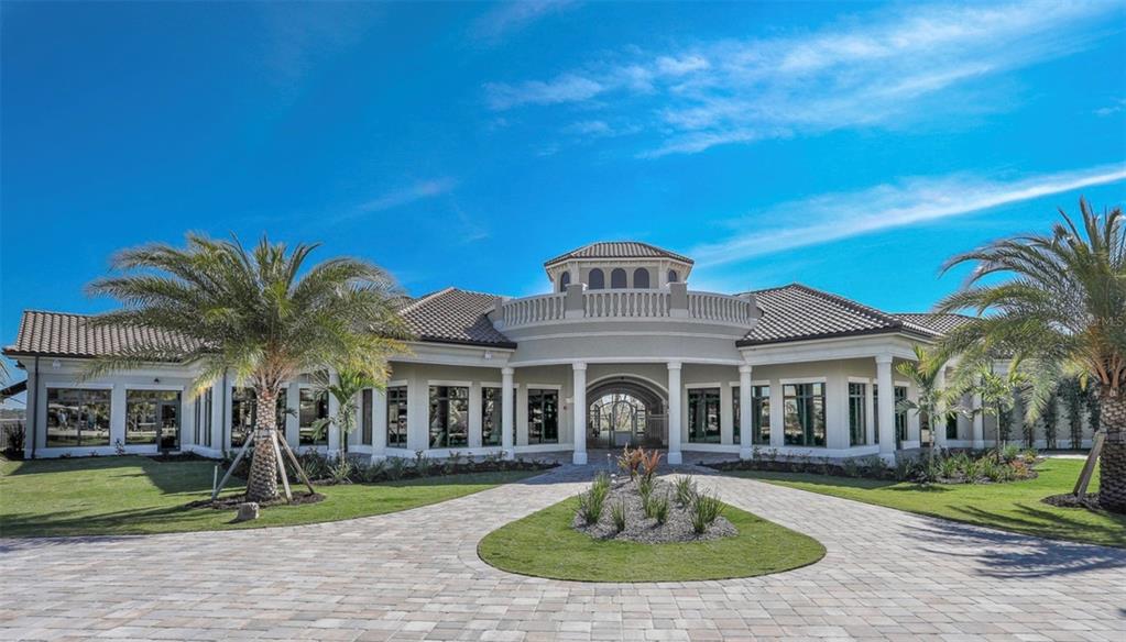 A single-story house with a circular driveway, palm trees, and a central arched entryway — 16814 VARDON TERRACE UNIT 201, BRADENTON, FL