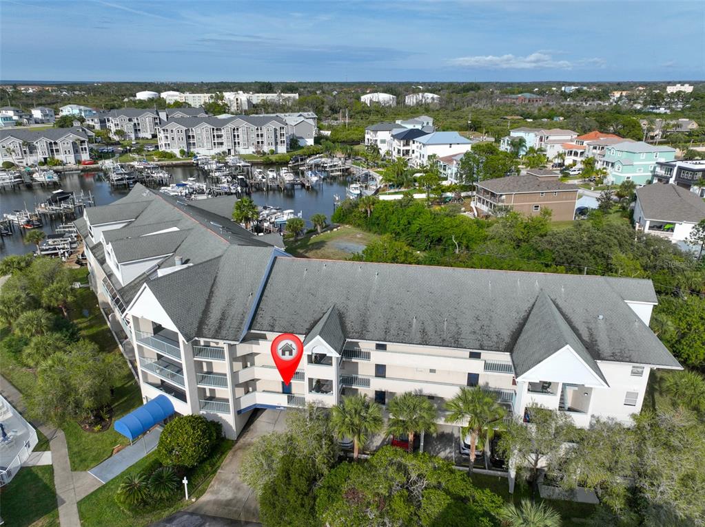 An aerial view shows a multi-story residential building with a red location pin marker — 5567 SEA FOREST DRIVE UNIT 122, NEW PORT RICHEY, FL