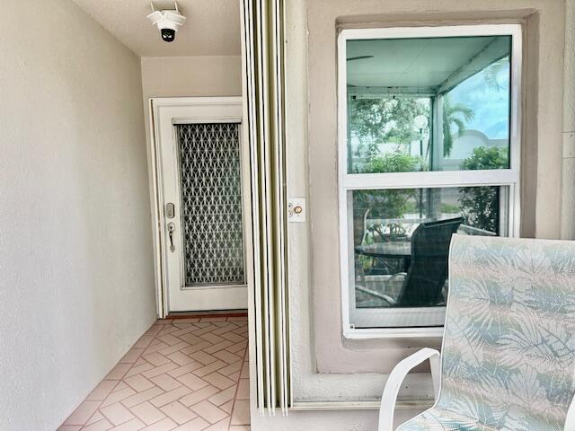A covered porch features a white door with a security screen and a large window — 18730 Stewart Circle # 5, Boca Raton FL 33496, BOCA RATON, FL