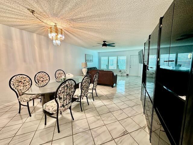 A dining area with a glass table and floral chairs sits before a living room — 18730 Stewart Circle # 5, Boca Raton FL 33496, BOCA RATON, FL