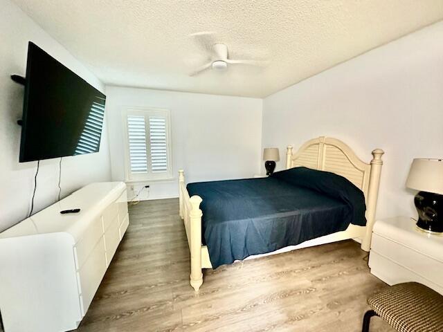 A bedroom features a bed with a dark cover, a white dresser, and a television — 18730 Stewart Circle # 5, Boca Raton FL 33496, BOCA RATON, FL