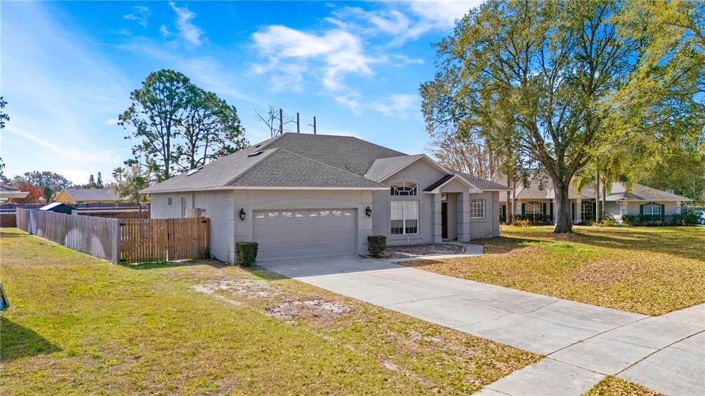 A single-story house with a gray stucco exterior, a two-car garage, and a concrete driveway — 134 ESTATES CIRCLE, LAKE MARY, FL